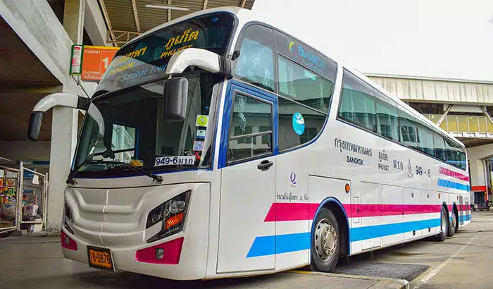 Autobus della compagnia Sombat Tour parcheggiato al Terminal Sud di Bangkok, con distintive strisce blu e viola, operante tra Phuket e Bangkok.
